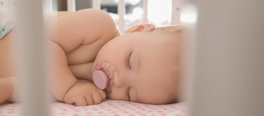 bebé durmiendo en su cuna con un chupete